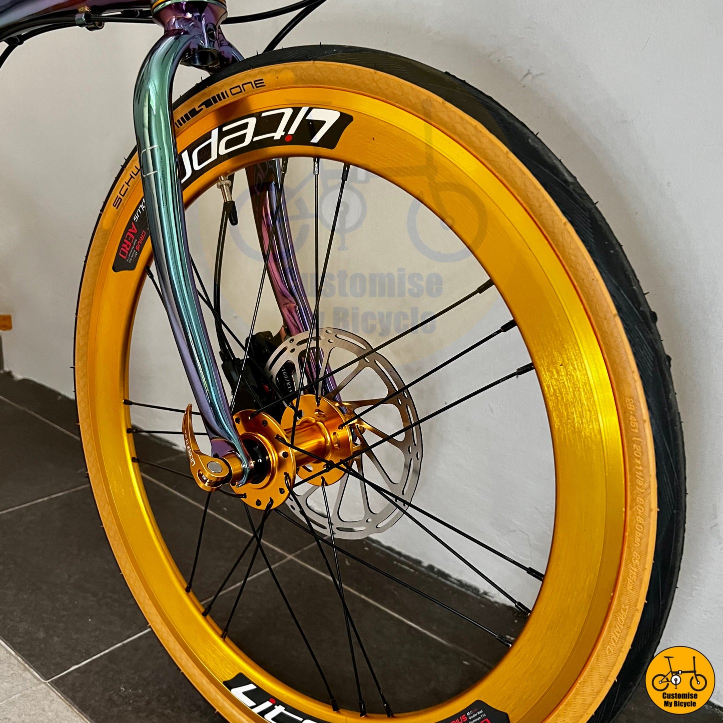 Lightweight foldable bicycle with a sleek gold-accented wheel
