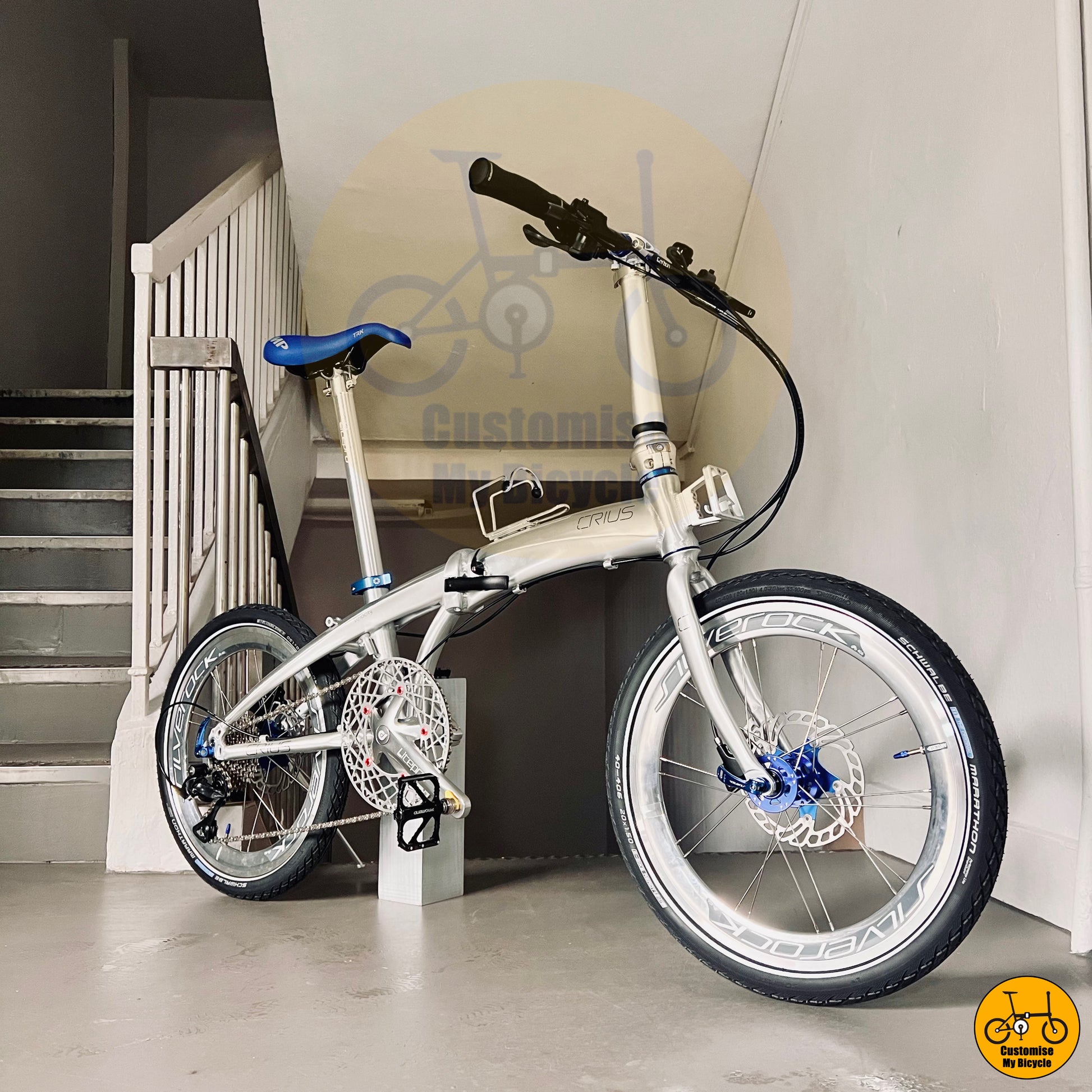 Crius Velocity 20-inch folding bike with a platinum silver frame and blue accents
