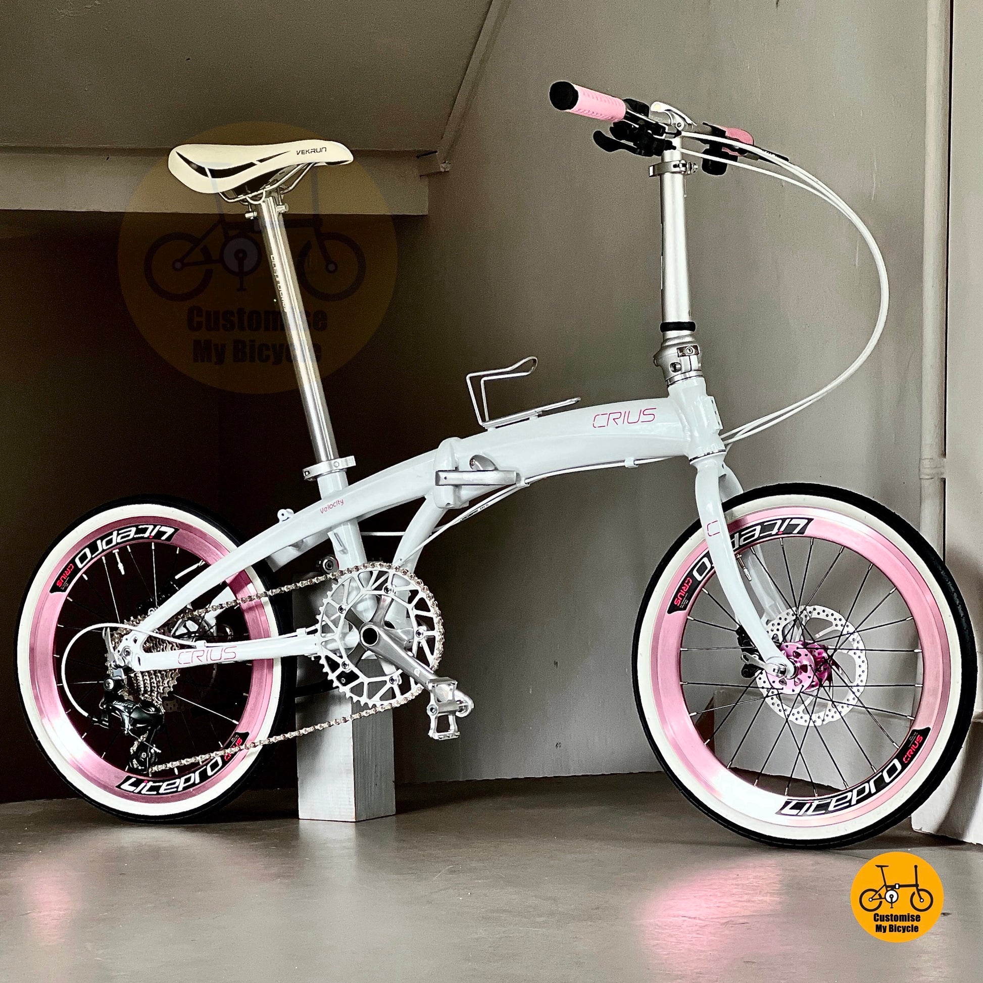 Crius Velocity folding bike in white frame with baby pink rims and accents  
