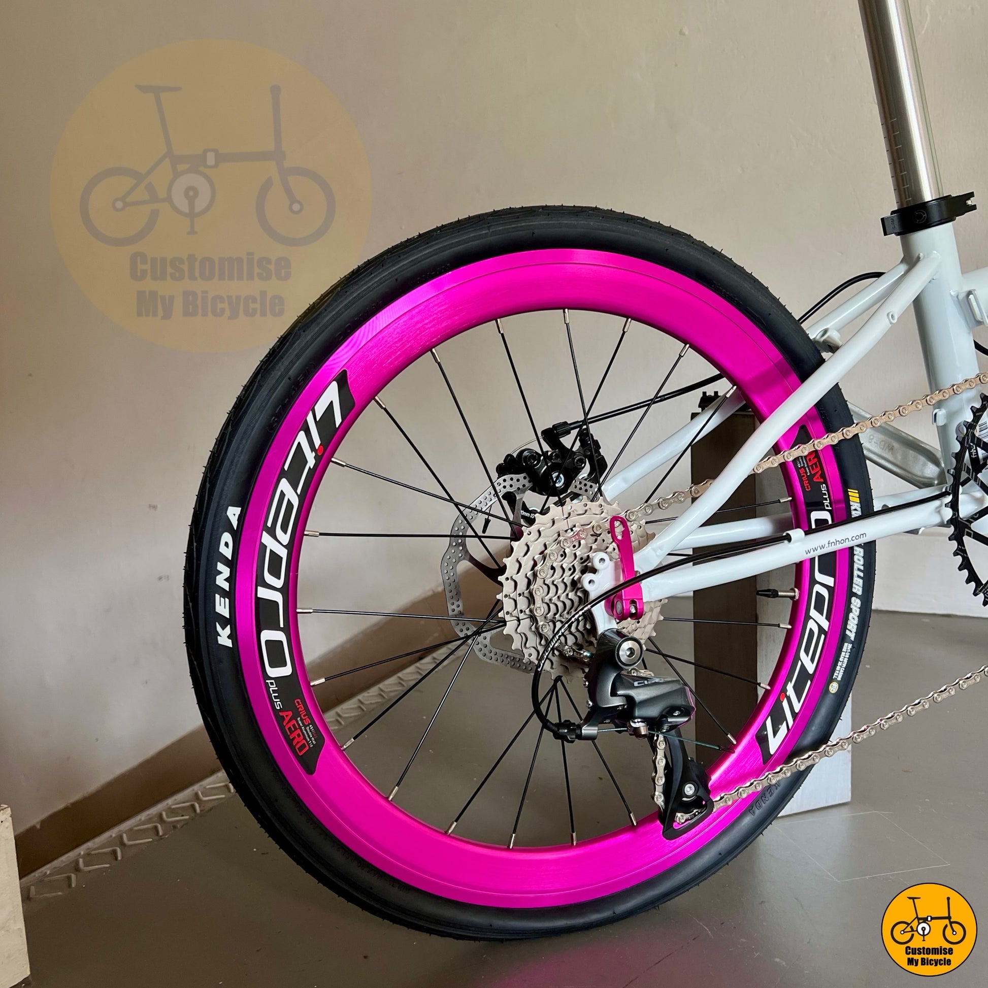 Folding bike with CST/Kenda tyres and pink details
