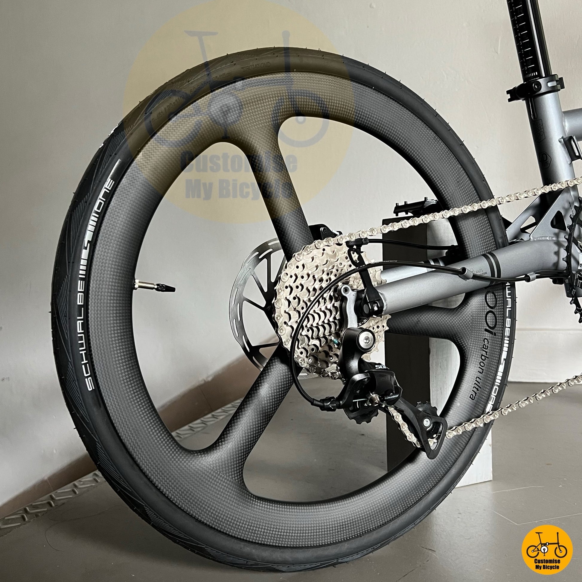 Folding bicycle with alloy frame, trispoke wheels and compact geometry
