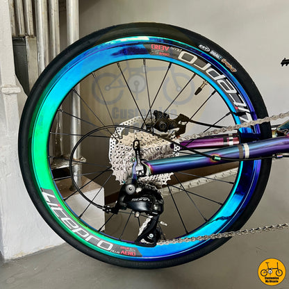 Folding bicycle with shimmering rainbow accents on the frame and wheels
