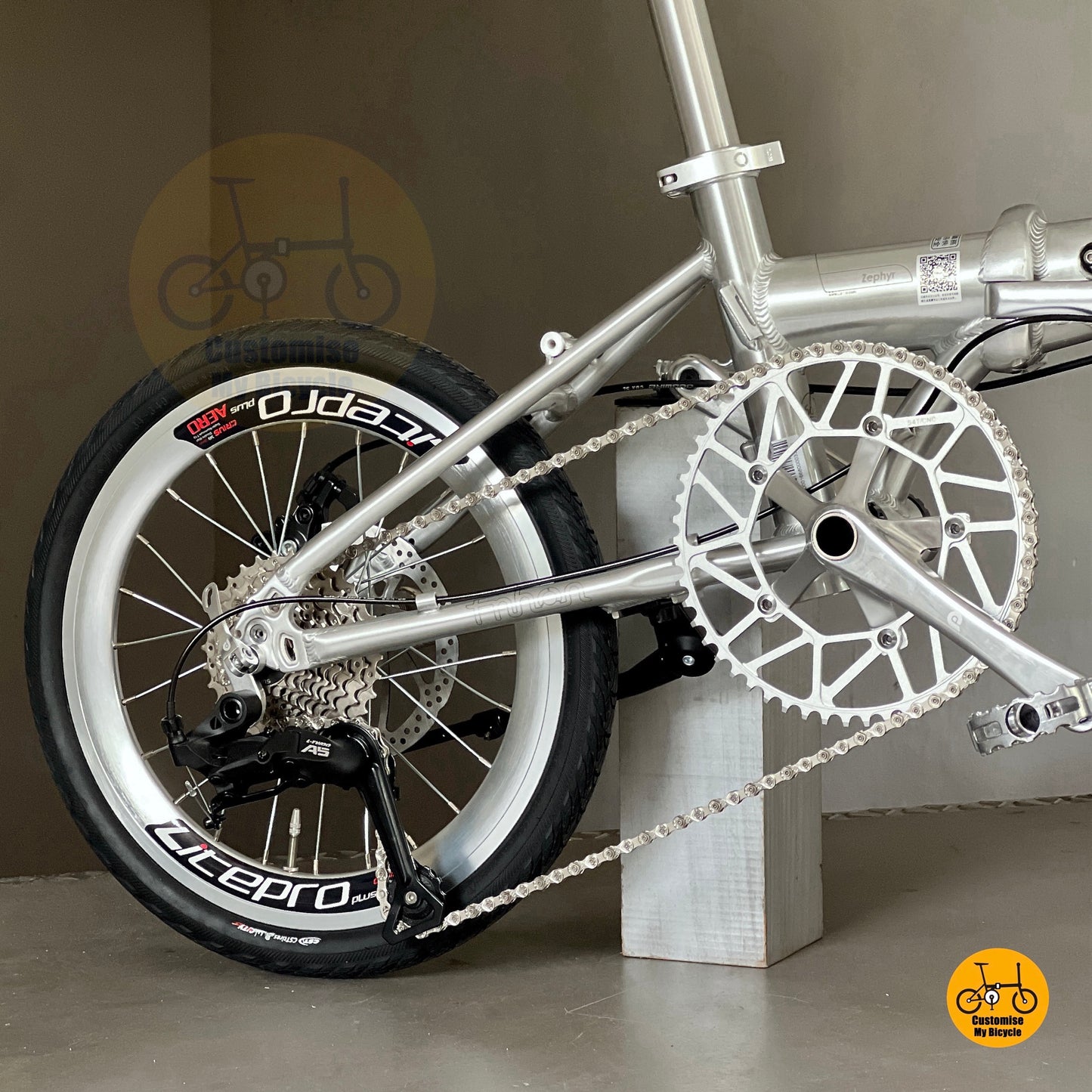 Close-up of Fnhon Zephyr polished silver crankset and chainring, showing CNC-machined details and reflective finish.
