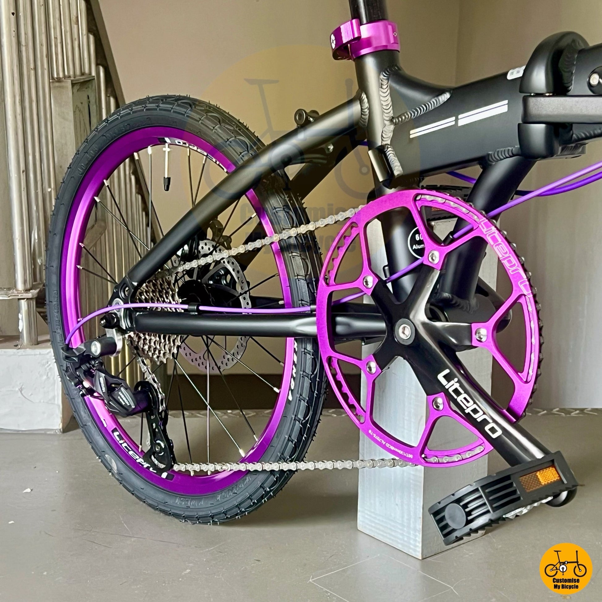 Sleek folding bike frame with matching purple brake cable and chainring
