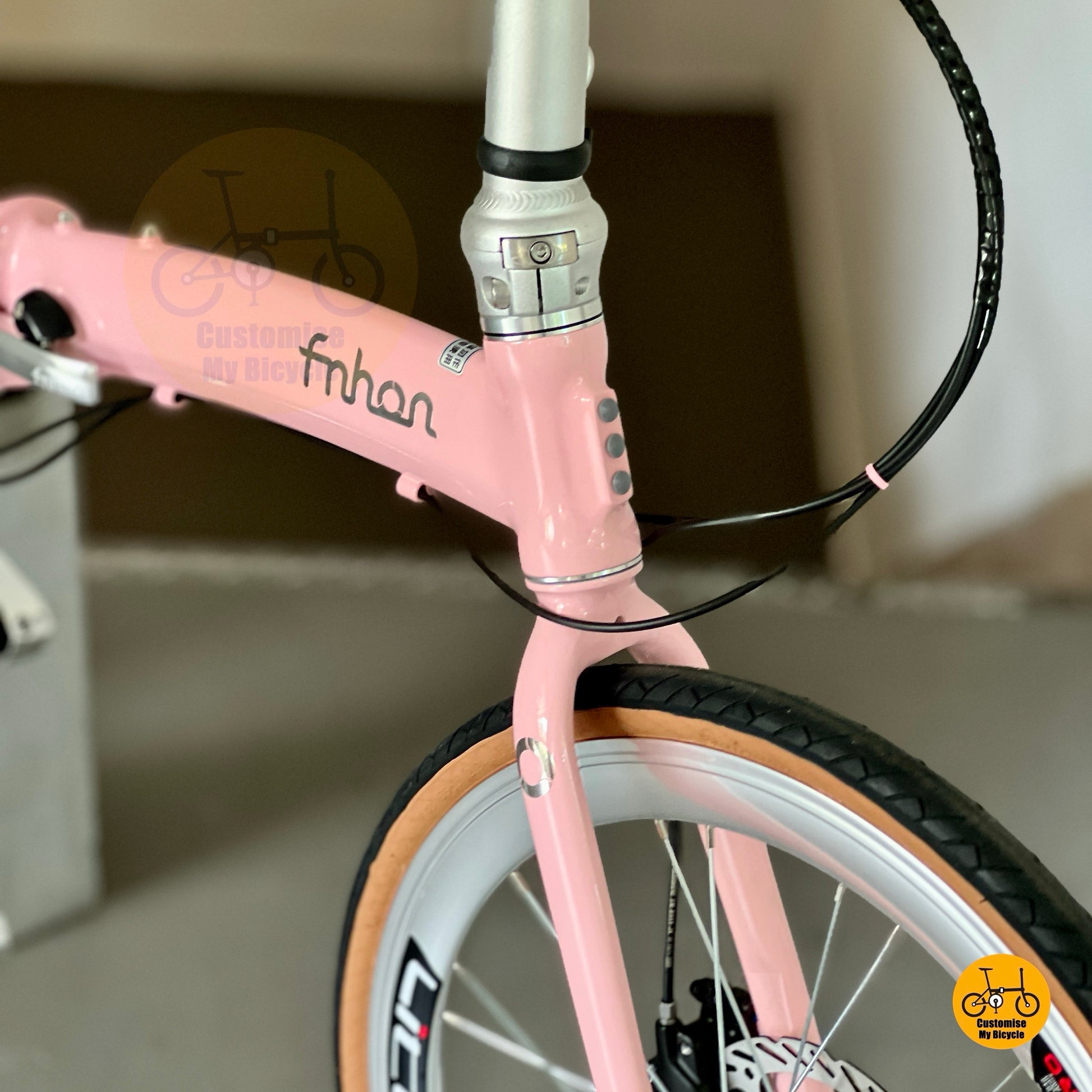 Close-up of a pink bicycle with 'fnhon' branding on a blurred background