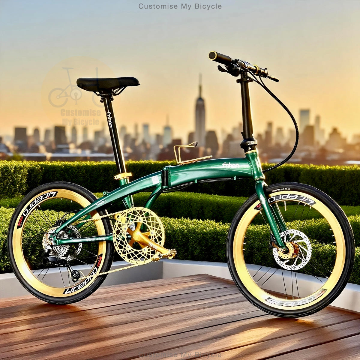 A green folding bicycle with gold accents and cream-colored tire sidewalls is parked on a wooden deck with a city skyline and hedges in the background.